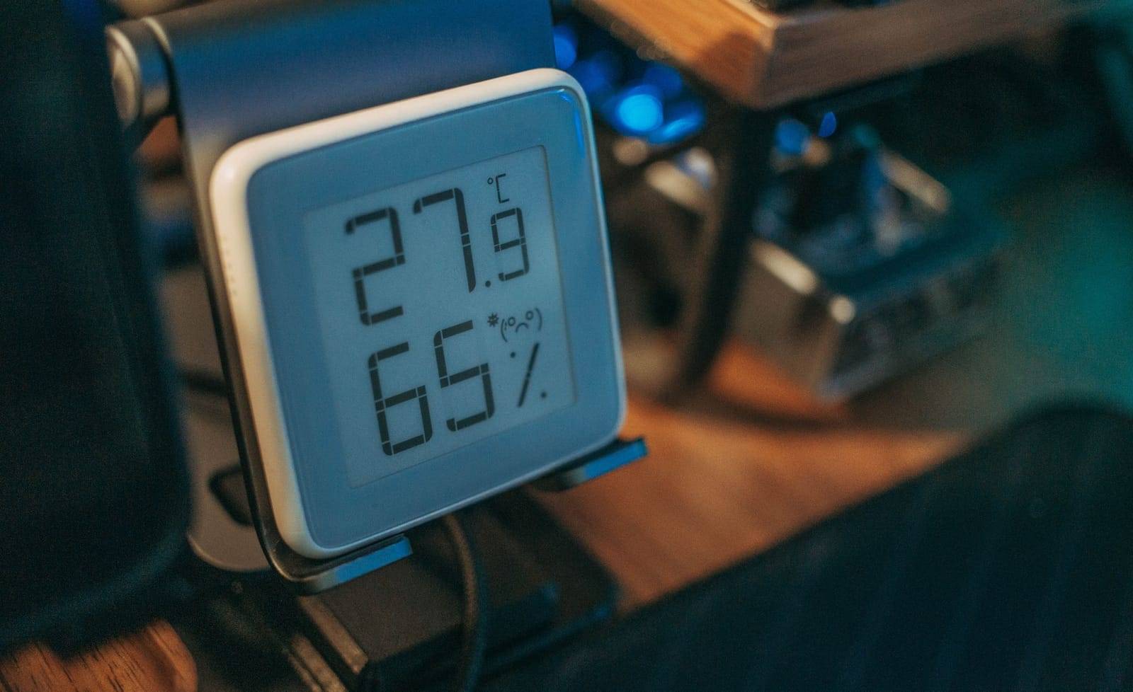 A small digital thermometer-hygrometer showing 27.9 °C and 65% relative humidity